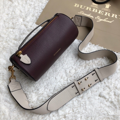 Burberry巴寶莉 新款 購入正品打造 採用頂級小牛皮…皮紋手感都跟正品毫無差距 好貨來得慢，但來得精 Burberry最新款圓柱形小號包，採用雙色皮革，搭配軍風靈感束帶，可斜背於肩部或圍於腰部。21*11*11cm