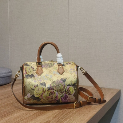 LV路易威登 M21317 本款 Speedy Bandoulière 25 手袋取材金屬質感塗層帆布，呈現絢麗毛茛的矚目綻放，講述 Nicolas Ghesquière 為 2022 秋冬時裝秀培植的花卉主題